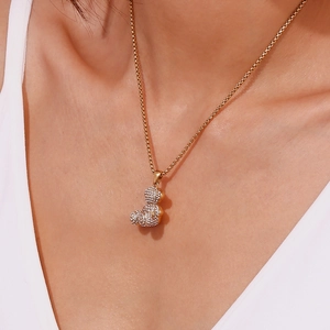 Macro shot of 18K gold plated square pearl chain with a sparkling crystal teddy bear pendant