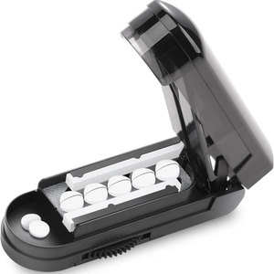 Portable black pill cutter with multi-compartment divider showing internal cutting structure