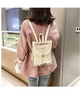 Detail of transparent PVC backpack featuring an interior canvas drawstring pouch and metal clasp
