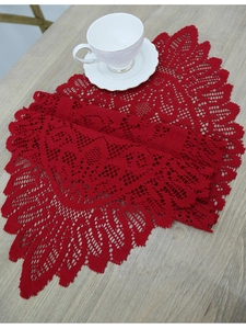 Close-up of red crochet lace table runner with intricate hollow patterns on wood surface