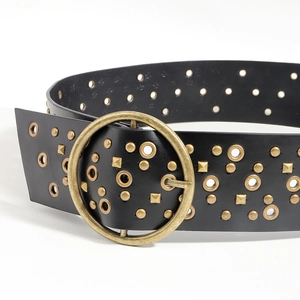 Detail of vintage black leather belt featuring brass round buckle and metallic studs