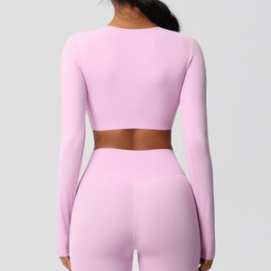Vue arrière d'un ensemble de yoga rose extensible avec crop top manches longues et legging