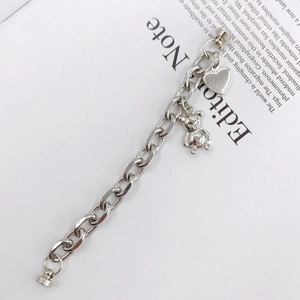 Catena per cellulare in metallo argento con ciondoli a cuore e orso su un libro aperto