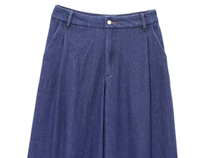 Dettaglio ravvicinato dei pantaloni in denim blu scuro a vita alta con gamba larga e pieghe