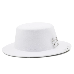 Detailed close-up of a white boater hat with silver safety pins and metal rings decor