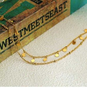Detail of double-layer gold plated necklace with spotted geometric round disk pendants