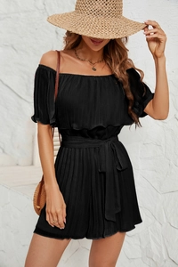Detail of black off-the-shoulder pleated jumpsuit with bow tie waist and ruffled sleeves