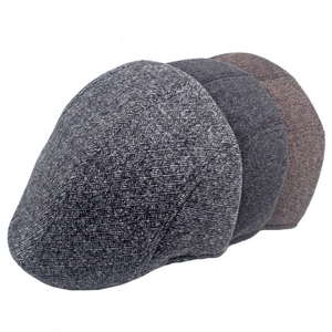 Detailed view of layered winter flat caps in grey and brown textured wool blend fabric