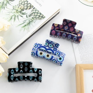 Three-piece large hair claw set with bohemian evil eye patterns in blue, purple, and black