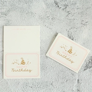 Minimalist cream birthday card set with elegant gold Happy Birthday script on marble surface