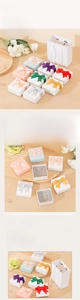 Detailed view of colorful jewelry box set with ribbon bows and matching white gift bag