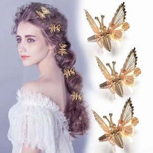 Macro detail of three golden butterfly hair clips with hollow wings on model