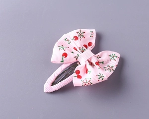 Detailed close-up of pink ribbon hair clip with cherry print and metal duckbill clip