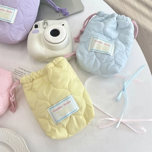 Detailed view of quilted cotton drawstring pouches in four pastel macaron colors