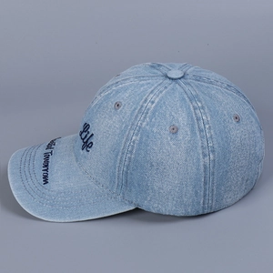 Detail view of washed blue denim baseball cap featuring vintage letter embroidery