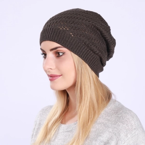Detailed close-up of dark brown slouchy beanie with intricate hollow knit pattern textures