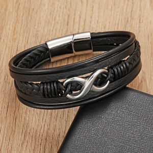 Braided leather multi-layer bracelet with silver infinity clasp on a wooden surface