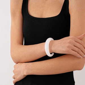 Close-up of white translucent resin cuff with unique vertical textured finish on wrist
