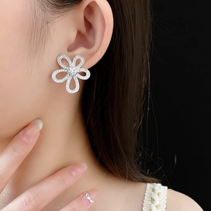 Gros plan d'un mannequin portant des boucles d'oreilles fleurs avec oxydes de zirconium