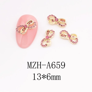 Detail showing pink rhinestone bow nail art charms on golden metal base 13x6mm size