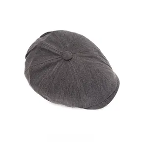 Detailed top view of dark grey herringbone newsboy hat with textured woven fabric