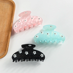 Trois élégantes pinces à cheveux marguerites en rose cyan et noir avec des strass