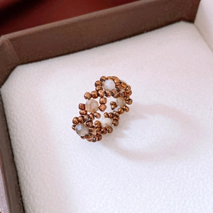 Macro shot of vintage beaded ring with bronze beads and faceted clear quartz stones