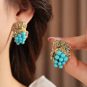 Detail of vintage grape leaf earrings with turquoise beads and sparkling rhinestones