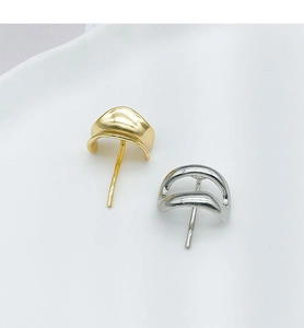 Detail view of minimalist curved metal earrings in gold and silver finishes