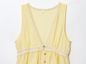 Detail of yellow sleeveless V-neck top showing delicate lace trim and textured fabric