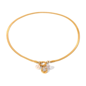 Golden blade chain necklace with pearl and sparkling zircon pendants on white background