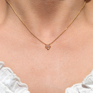 Primo piano di una collana con ciondolo a fungo placcato oro con opali sul collo del modello