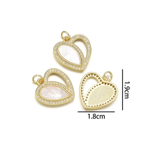 Detailed view of heart shell pendant with gold plating and rhinestones, size 1.9cm x 1.8cm