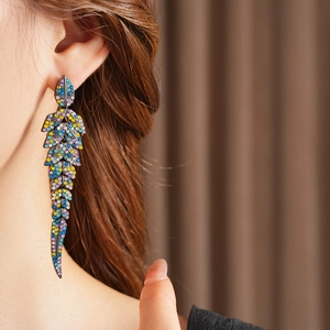 Gros plan détaillé de boucles d'oreilles vintage en forme de feuille avec strass colorés