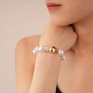 Gros plan du bracelet de perles baroques vintage avec une perle irrégulière en métal doré