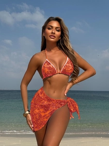 Détail d'un bikini paisley orange avec bordure en dentelle blanche et paréo assorti