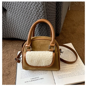 Detailed view of plush tote bag in brown suede with white lamb wool pocket and strap