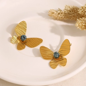 Elegant 18K gold butterfly earrings featuring vintage turquoise stones on white plate