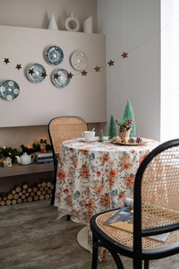 Detailaufnahme der runden Samt-Weihnachtstischdecke mit Weihnachtsstern- und Zapfenmotiven