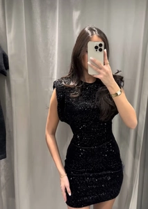 Gros plan détaillé sur le tissu à paillettes noires scintillantes d'une mini robe sans manches