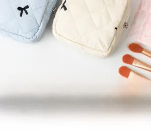 Detail of quilted sanitary pad bags featuring black bows and rhombic stitching details