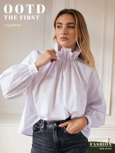 Detail of high stand collar with ruffled edges and puff sleeves on white shirt