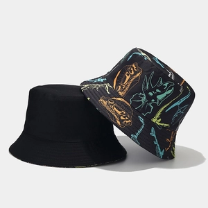 Detail of reversible bucket hat featuring colorful dinosaur skeleton patterns and black cotton fabric