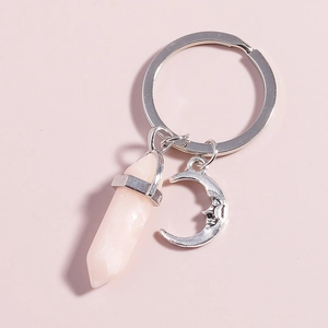 Detailed view of pink hexagonal crystal prism and silver moon pendant on a keyring