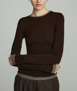 Detail of wool knit top showing brown contrast ribbed cuffs and hem on the sleeve