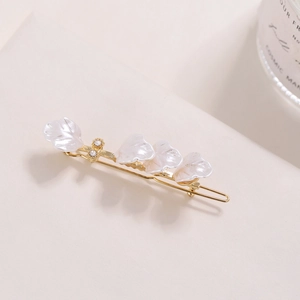 Golden flower hair clip featuring white pearlescent petals and small rhinestones