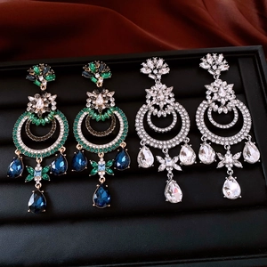 Gros plan de boucles d'oreilles vintage avec strass et cristaux sur plateau à bijoux