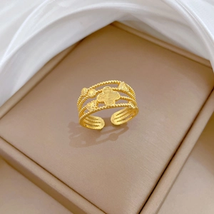 Dettaglio dell'anello a quadrifoglio e cuore dorato con bordi perlati su espositore di lusso
