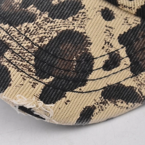 Detailed close-up of leopard print baseball cap with distressed edges and stitching