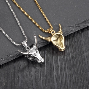 Bull head pendant necklace in gold and silver finish on stone and wood background